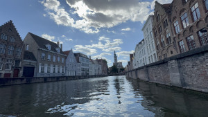 belgium-bruges-canal-cruising-2025-08-24-15.47.26-300x169 从水面远眺布鲁日老城，阶梯形屋顶、古老砖墙与教堂尖塔构成经典的城市天际线。 